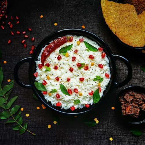 a black bowl filled with rice and vegetables