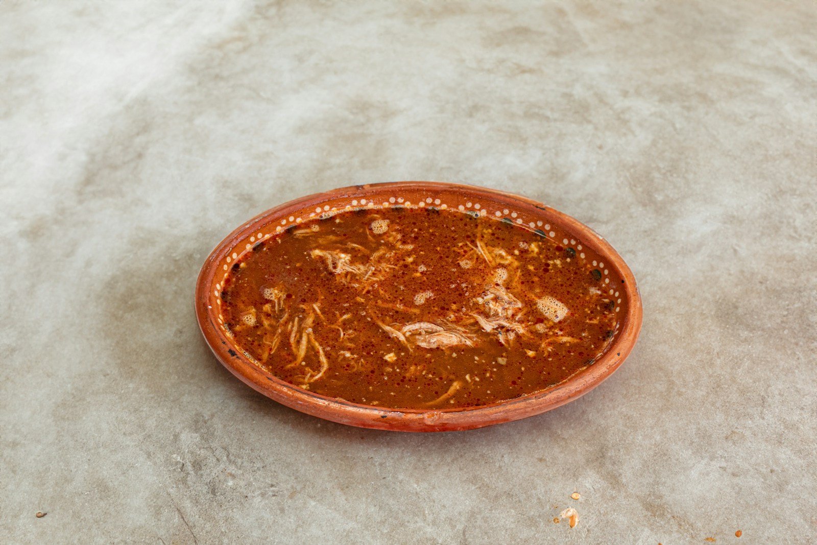A small orange bowl sitting on top of a table