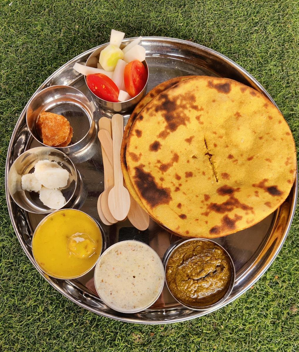 A delicious assortment of traditional Indian foods served on a silver plate, showcasing vibrant flavors.