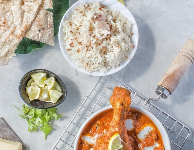 a table topped with plates of food and a bowl of rice